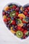 Colorful rainbow fruit in heart shape bowl.