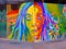 Colorful rainbow street art mural of woman& x27;s face with plants and crab claw in playa del carmen mexico