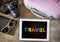 Colorful rainbow travel word lgbt equality symbol lettering on digital computer tablet and traveler accessories on wooden