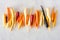 Colorful raw rainbow carrots arranged in a row over a white marble background