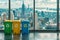 Colorful recycling bins against a cityscape background.