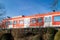 Colorful red train crossing an arched bridge