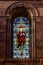 Colorful religious stained glass window inside St. David's cathedral in Pembrokeshire, Wales, UK