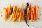 Colorful roasted rainbow carrots arranged in a row over a white marble background