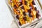 Colorful roasted vegetables on tray with parchment. Mix of carrots, beets, turnips, rutabaga, onions. Vegetarianism, veganism,