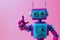 A colorful robot with pink and blue hues is pointing at something.