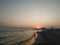 Colorful romantic sky during evening on a sandy beach with a view on wavy sea during sunset