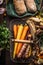 Colorful root vegetables in harvest basket on dark wooden kitchen table background, top view. Healthy and clean food and eating