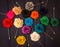 Colorful rose brooches on a grey textile