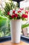 Colorful roses flower in big white vase in conner of living room