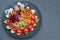 Colorful salad with mango, radicchio, radish, carrots, roasted sunflower seeds, heart shaped cherry tomatoes, walnuts and