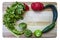 Colorful salsa frame - Cutting board with cilantro and tomatillos and assorted hot and sweet peppers arranged around the sides and