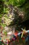 Colorful satin ribbons tied by tourists for good luck on the wooden railings of a small bridge in the mountains among the trees