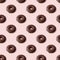 Colorful seamless pattern of chocolate donuts with light pink background. Sweetness pastel colors. Confectionery banner