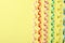 Colorful serpentine streamers on yellow background, flat lay. Space for text