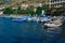 Colorful ships and boats in water at piers among houses and buildings of town balaclava near  mountains, reflections in ripples