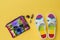 Colorful shoes for women, seashells, sunglasses and a bag on a bright yellow background. The concept of summer vacation. Flat lay.