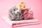 Colorful shower puffs, loofah sponge and towel on pink background