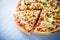 Colorful sliced pizza with mozzarella cheese, chicken, sweet corn, sweet pepper and parsley close up