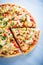 Colorful sliced pizza with mozzarella cheese, chicken, sweet corn, sweet pepper and parsley close up