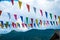 Colorful small flags with cloudy sky.