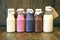 Colorful Smoothies at the bottles. Colorful drink, milk shake in bottle with fresh vegetables and superfoods on a wooden