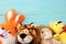 Colorful soft animal toys on blue wooden background. Top view. Toys in the table