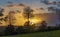 A colorful spectacle arises as the sun sets behind an approaching rainstorm over the rolling countryside near Montpinchon in Norma