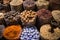 Colorful spices nuts dried flowers minerals and pestle for cooking at open air spice market