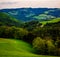 Colorful spring landscape panorama of a rural idyllic countryside in Austria with trees, forest, fields, hills