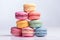 Colorful stacked macarons on a white background.