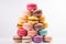 Colorful stacked macarons on a white background.