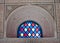 Colorful stained-glass window in ornate stone arch
