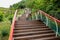 Colorful steel railings of planked stairway ascending along hillside