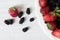 Colorful strawberries and mulberries in white bowl