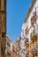 Colorful street with balconies and tower of San Lorenzo Parish church in the background, CÃ¡diz SPAIN