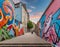 Colorful street mural depicting social issues in an urban setting