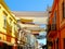 Colorful street and patio awnings over city street across between buildings