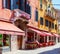 Colorful street with tables of cafe at a sunny morning, Venice, Italy