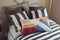 Colorful striped pillow on black striped bedding in light brown