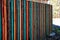 Colorful striped wooden fence with a window for watching animals in the corral of the zoo park. mesh window for a safe view of the