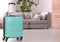 Colorful suitcase packed for journey in living room.