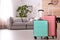 Colorful suitcases packed for journey in living room.