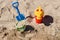 Colorful summer beach toys, bucket, sprinkler and shovel on sand