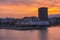 Colorful sunrise with fiery sky over the Piraeus port and city. Passenger vessels are docked at the jetty of the port