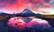 Colorful sunrise over the snow covered mountains and a lake
