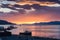Colorful sunrise in the port of Ushuaia, with a docked ship in the foreground and some ships on the horizon