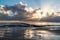 Colorful sunrise with sun rays and clouds mirroring in the water captured on the German island Usedom