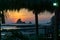 Colorful sunset on the beach in Nicaragua with a rock and banana leafes in the front.