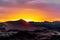 Colorful sunset behind a huge sand dune landscape.